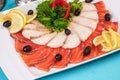 Mediterranean fish sliced Ã¢â¬â¹Ã¢â¬â¹salmon, tuna and trout with vegetables, greens, lemon and black olives Royalty Free Stock Photo